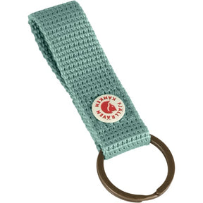 Tuo ikonisen Kånken tyylin osaksi arkea Fjällräven Kånken Keyring avaimenperällä. Tämä käytännöllinen ja tyylikäs avaimenperä on saanut inspiraationsa suositun Kånken repun yksityiskohdista. Se sopii avainten säilyttämiseen ja antaa samalla persoonallisen lisän laukkuun, reppuun tai avainnippuun.